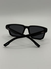 Black sunglasses with 'OBL' branding on a light gray background