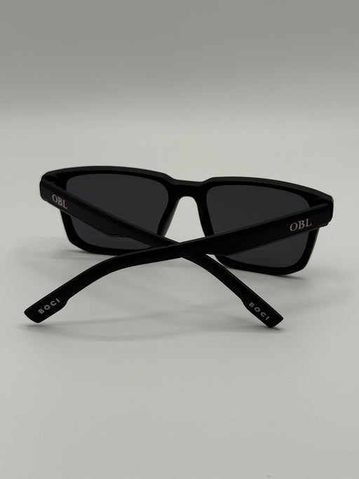 Black sunglasses with 'OBL' branding on a light gray background