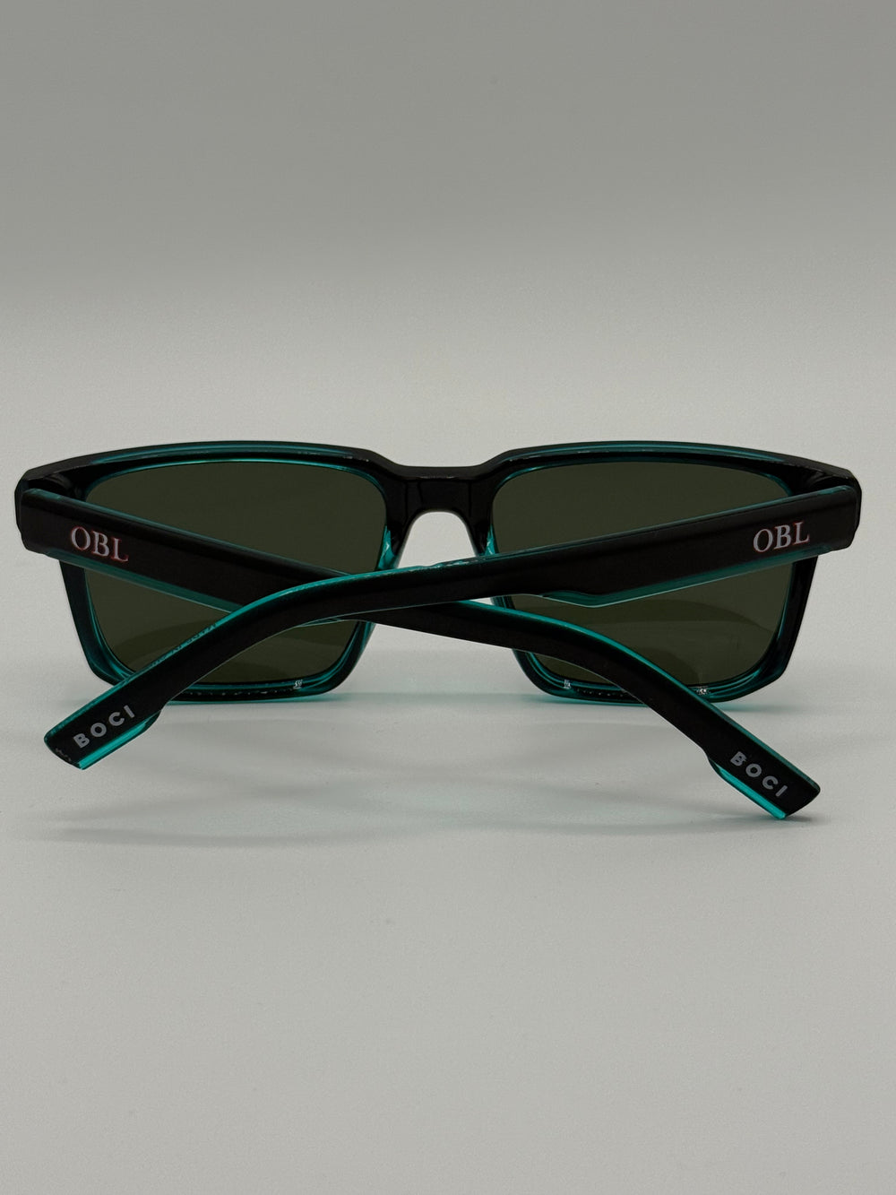 Black & Teal Green Sunglasses with 'OBL' branding on back X BOCI